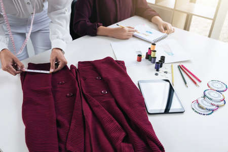 Two professional stylish fashion designer working as fashion designers measure as sketches in workshop of new collection in art, Creative Design and Artistic Concept.の写真素材