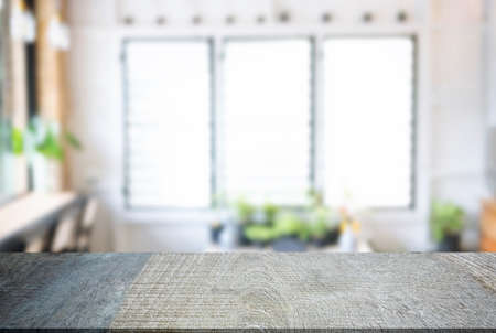 Empty wooden table and blurred background of abstract in front of restaurant or coffee shop for...