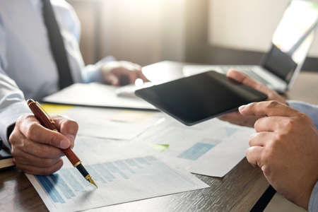 Business team meeting working with new startup project, discussion and analysis data the charts and graphs. Digital tablet calculator, laptop computer using, Business finances and accounting concept.の写真素材
