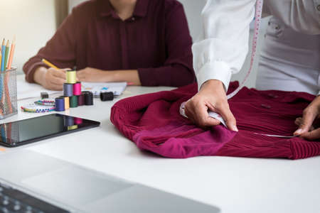 Two young dressmaker or designer colleagues working and discussing fashion project designers and drawing sketches for clothes, profession and job occupation, Fashion Designer Stylish Concept.の写真素材
