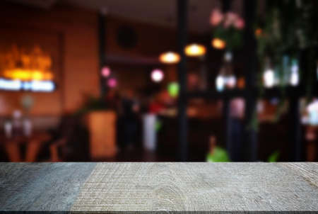Empty wooden table and blurred background of abstract in front of restaurant or coffee shop for...