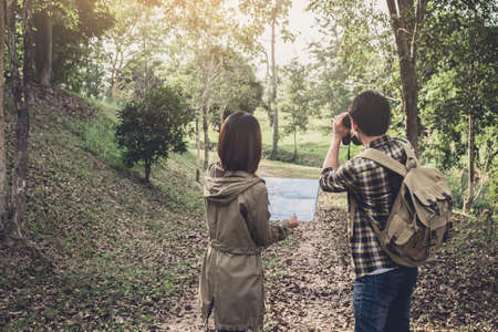 Two Young Traveler with backpack, are holding map relaxing in greens jungle and enjoying with outdoor forest on background Summer vacations and Lifestyle hiking concept.の写真素材