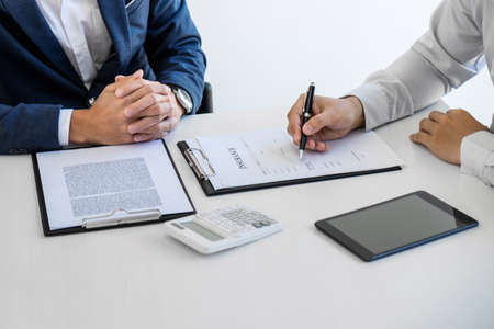 Businessman will be signing a car insurance policy, Agent man is holding the document and waiting for his reply to finish.の写真素材