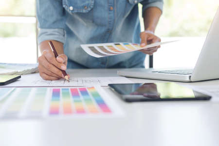 Creative creativity graphic designer working with graphics tablet,laptop and smart phone, colour chart at workplace on wooden desk , colour ideas style concept.の写真素材