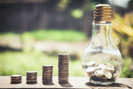 Stacking coins and money growing for saving, Coin in glass bottle with money stack for business planning investment.の写真素材