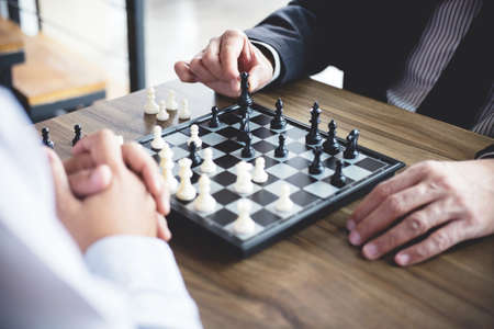 Confident businessman colleagues playing chess game overcome the fear of confrontation to development analysis new strategy plan, leader and teamwork concept for success.の写真素材