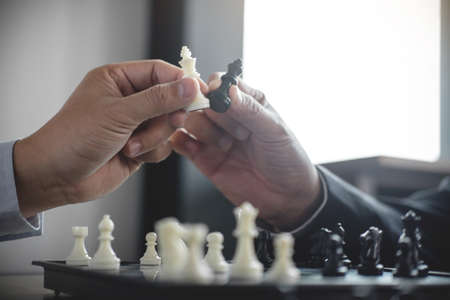 Confident businessman colleagues playing chess game overcome the fear of confrontation to development analysis new strategy plan, leader and teamwork concept for success.の写真素材