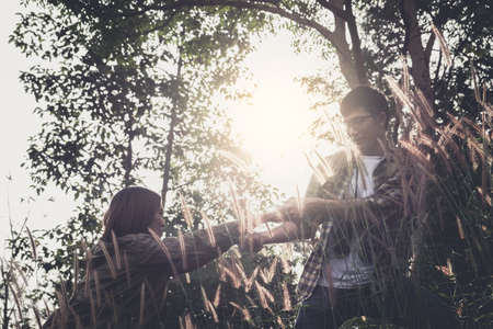 Helping hand hiking get help friend from man in a dangerous situation to hike in the mountains.の写真素材