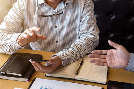 Two Business man or accountant working Financial investment, writing report Analyze business and market growth and calculating cost on financial document data graph, Accounting, Economic, commercial.の写真素材