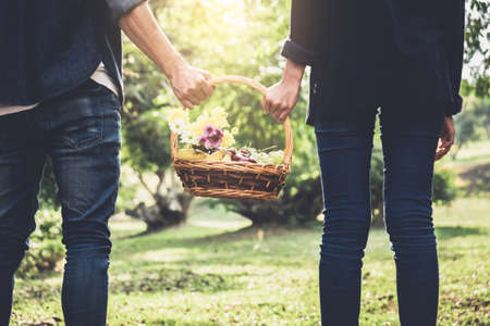 Couple in love walking and holding a picnic basket on nature outdoor background.の写真素材