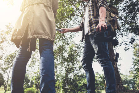 Two Young Traveler with backpack, are holding map relaxing in greens jungle and enjoying with...