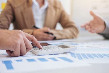 Team work process, business managers crew working with new start up project. laptop, tablet on wood table in office.の写真素材