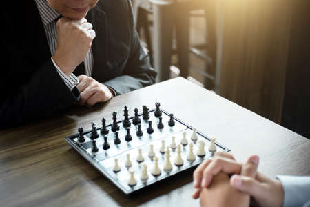 Confident businessman colleagues playing chess game overcome the fear of confrontation to development analysis new strategy plan, leader and teamwork concept for success.の写真素材