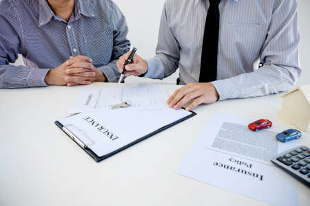 Car and Home insurance concept, broker agent presenting and consult to customer to decision making sign insurance form agreement, home and car model.の写真素材