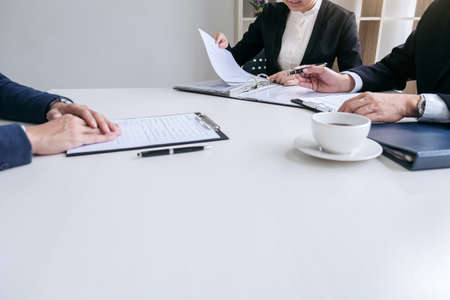 Interviewer or Board reading a resume during a job interview, Employer interviewing a young male job seeker for recruitment talking in modern office, employment and recruitment concept.の写真素材