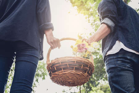 Couple in love walking and holding a picnic basket on nature outdoor background.の写真素材