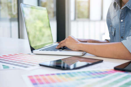 Creative creativity graphic designer working with graphics tablet,laptop and smart phone, colour chart at workplace on wooden desk , colour ideas style concept.の写真素材