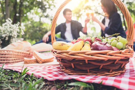 Couple in love drink a orange juice and fruits on summer picnic, leisure, holidays, eating, people and relaxation concept.の写真素材