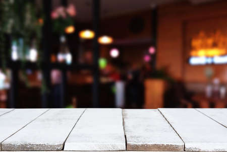 Empty wooden table and blurred background of abstract in front of restaurant or coffee shop for display of product or for montage.の写真素材