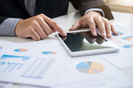 Business team two executive colleagues discussing and analysis working Financial investment on calculator with calculate on tablet Analyze business and market growth on financial document data graph.の写真素材