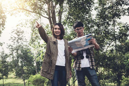 Two Young Traveler with backpack, are holding map relaxing in greens jungle and enjoying with...