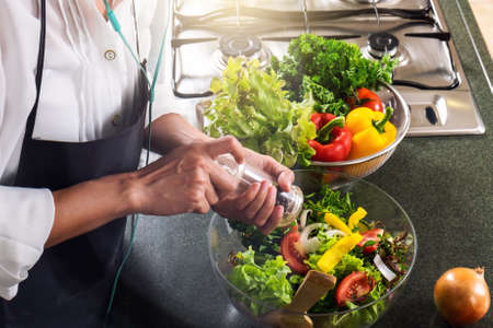 Young happiness Woman Cooking vegetables salad in the kitchen, Healthy food concept.の写真素材