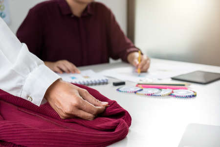 Two young professional Fashion designer colleagues working and project of drawing sketches for clothes in workplace with laptop, digital tablet and color charts, Fashion Designer Stylish Concept.の写真素材