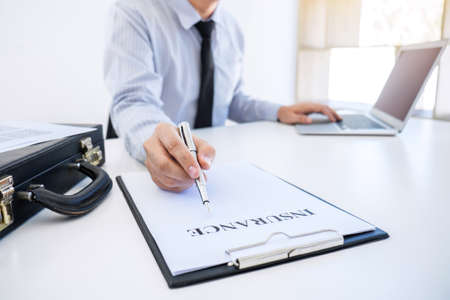 Insurance concept, businessman signing a car insurance policy.の写真素材