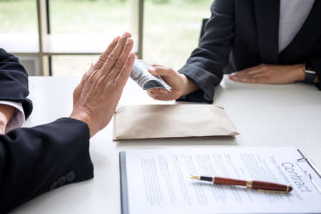 Bribery and corruption concept, senior businessman manager refusing receive money in the envelope to...