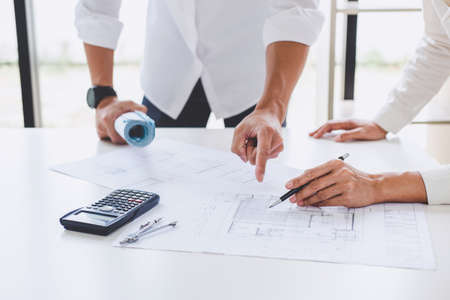 Architect or Engineer meeting working with partner on blueprint for architectural project in progress, construction and structure concept.の写真素材