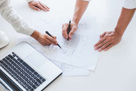 Architect or Engineer meeting working with partner on blueprint for architectural project in...
