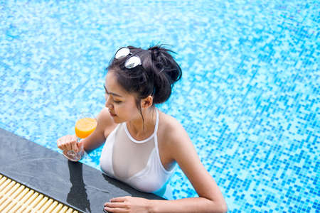 Summer fun in holiday, Happy beautiful woman lifestyle relaxing near luxury swimming pool and drink...