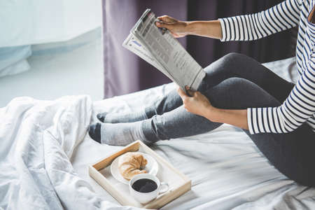 Relaxation and recreation, Young happiness woman on the bed with enjoying reading newspaper in...