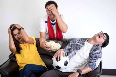 Group of friends fanclub watching soccer match on tv and cheering football team, celebrating with beer and popcorn at home, sports and entertainment concept.の写真素材