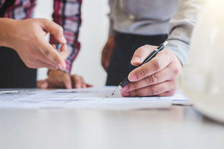 Architect or Engineer meeting working with partner on blueprint for architectural project in...