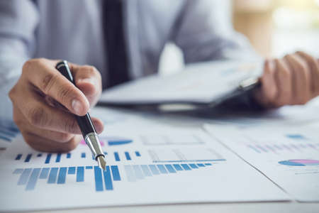 Business man or accountant working Financial investment on calculator with calculate Analyze business and market growth on financial document data graph and writing ,Accounting,Economic,commercial.の写真素材
