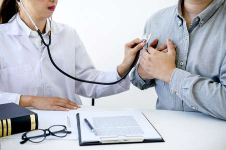 Female doctor checking heart beat of patient and recommend treatment methods and how to use medicine.の写真素材