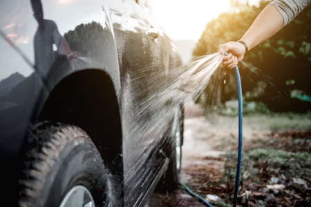 Man washing and cleaning car with spraying pressured water.の写真素材