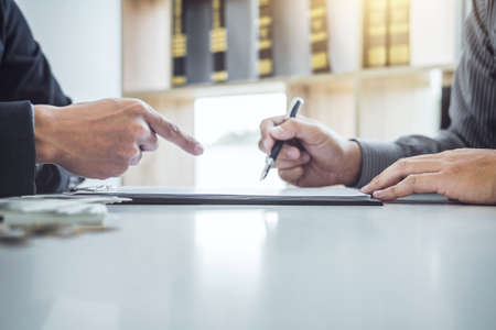 Man customer signing car document contract agreement, successful car loan contract buying or selling new vehicle and salesman pointing documents.の写真素材