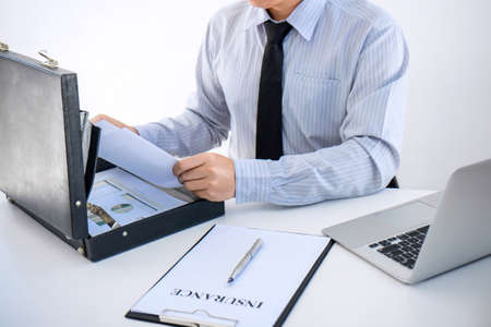 Insurance concept, businessman signing a car insurance policy.の写真素材