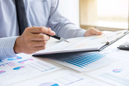 Business man or accountant working Financial investment on calculator with calculate Analyze business and market growth on financial document data graph and writing ,Accounting,Economic,commercial.の写真素材