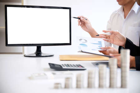 Business accountant or banker, Two business partner analysis with stock financial indices and growth stacking coin and financial costs wisely and carefully, investment and saving concept.の写真素材