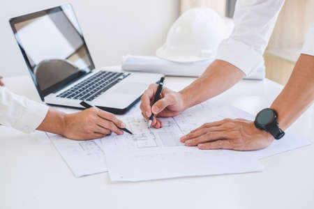 Architect or Engineer meeting working with partner on blueprint for architectural project in...