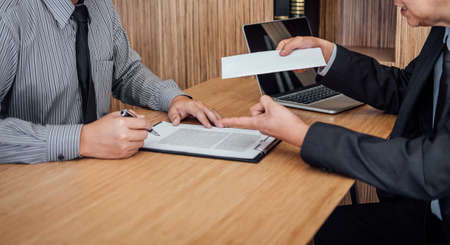 Hand of employer filing final remuneration after employee to write a document letter of resignation,...
