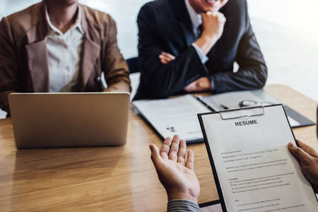 Business man holding his resume and explaining about his profile to two senior manager sitting in during job Interview.の写真素材