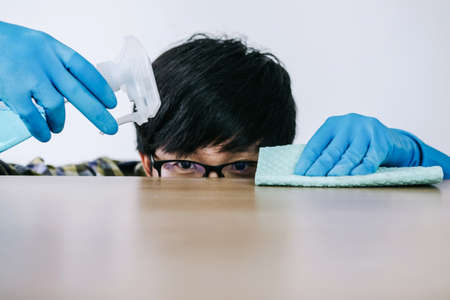 Husband housekeeping and cleaning concept, Happy young man wiping dust using a spray and a duster...
