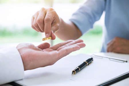 Husband and wife are signing decree of divorce (dissolution or cancellation) of marriage filing...