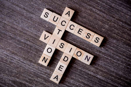Concept presented by crossword with words idea, vision, action and success with wooden cubes on...