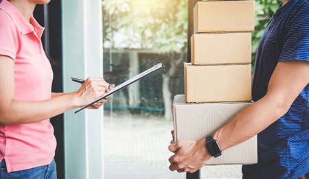 Home delivery service and working with service mind, Woman customer signing and receiving a...