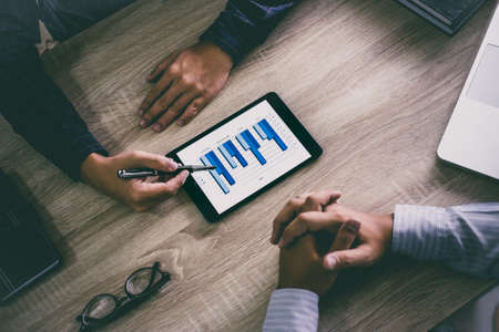 Two business executive conference presentation report of new plan marketing to development consulting business in company, using digital tablet.の写真素材
